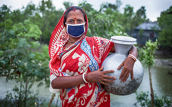 Woman carrying water jug.