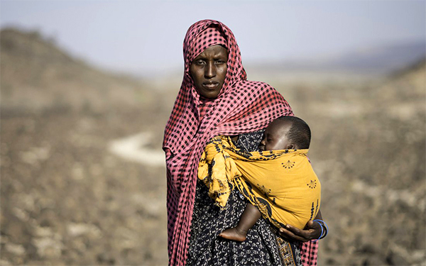 Woman balancing a child on her hip.