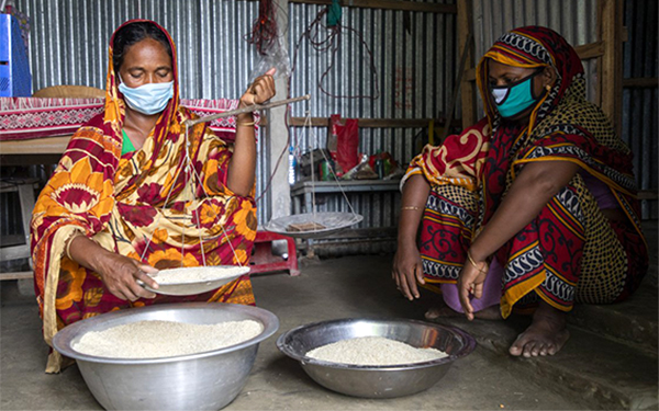 Woman weighing rice.